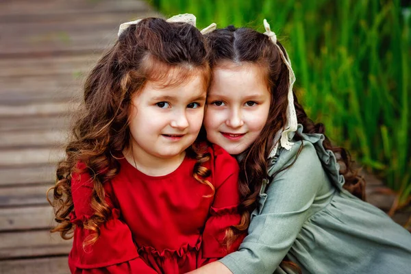 Duas Meninas Com Cabelos Longos Vestido Vermelho Verde Estão Sentadas — Fotografia de Stock