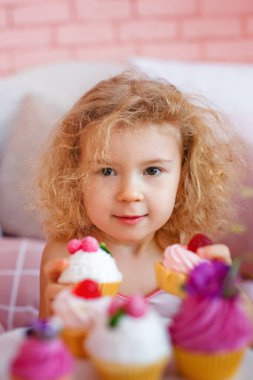 Seçici odaklanma. Ön planda pastaları olan sevimli beyaz bir sarışının portresi..