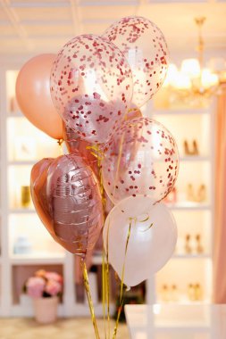 Soyunma odasının arka planında pembe ve şeftali rengi balonlar..