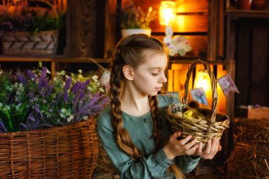 Yeşil elbiseli bir kız, içi tüylü ördek yavrularıyla dolu bir sepet tutuyor. Güzel bir kız neşeyle gülüyor ve samanlıkta hayvanlarla oynuyor. Paskalya Kompozisyonu
