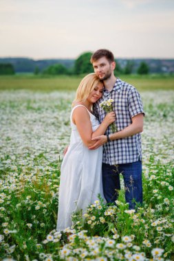 Genç bir çift gün batımında papatya tarlasında kucaklaşır. Tutku ve aşk kavramı