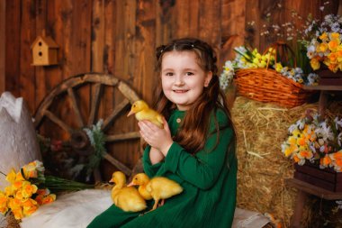 Stüdyoda oturan yeşil elbiseli bir kız samanlıkta yeni doğmuş hatunlarla ahşap bir geçmişi var. Güzel bir çocuk neşeyle gülüyor ve ördek yavrularıyla oynuyor. Paskalya Kompozisyonu