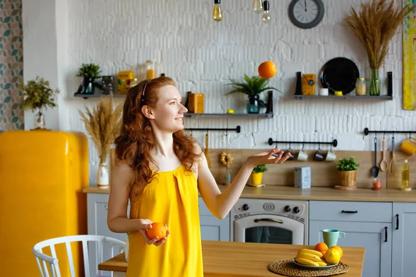 Portret Atrakcyjnej Rudowłosej Dziewczyny Żółtej Sukience Owocami Rękach Kuchni Wymiotuje — Zdjęcie stockowe