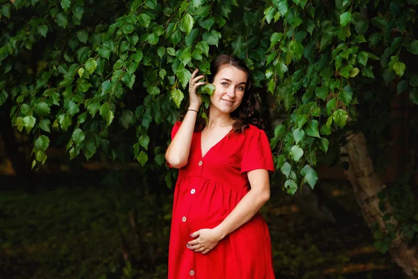 Yeşil Yaprakların Yanında Kırmızı Elbiseli Hamile Bir Kız Doğada Güzel — Stok fotoğraf