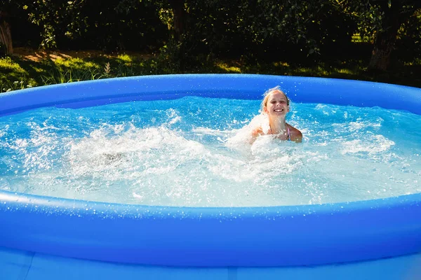 Uma Criança Está Divertindo Uma Piscina Borracha Uma Menina Espirra — Fotografia de Stock