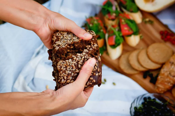 Una Mujer Parte Pan Negro Grano Picnic Naturaleza Enfoque Selectivo — Foto de Stock