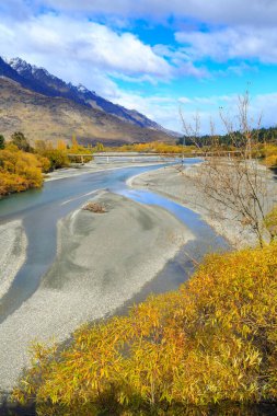 Sonbaharda Yeni Zelanda 'nın Otago bölgesindeki Shotover Nehri' nde. Arka planda Queenstown 'a giden bir köprü var.