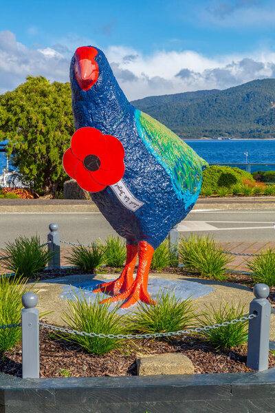 Те Анау, Саутленд, Новая Зеландия. Гигантская скульптура такахе, находящейся под угрозой исчезновения местной птицы, перед озером Те Анау. На нем гигантский мак в честь Дня Анзака. 25 апреля 2021 года
