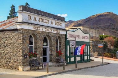 Cromwell Heritage Precinct, Cromwell, Yeni Zelanda 'daki tarihi altına hücum dönemi binaları. D A Jolly & Sons Seed & Grain Store (1870) ve Cromwell Pastanesi (yeniden yapılanma). 22 Nisan 2021