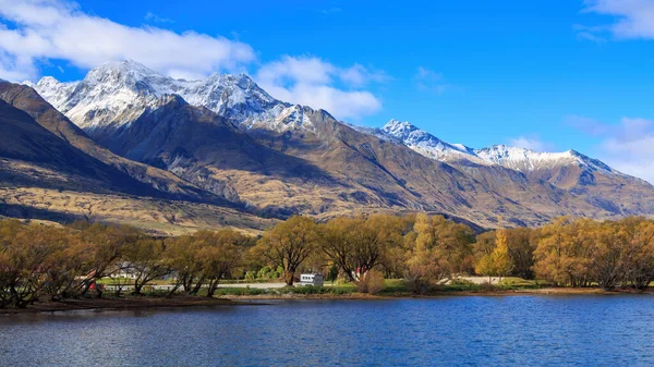 位于新西兰南岛瓦卡蒂普湖格莱诺奇的秋季全景 南方阿尔卑斯山前的一排湖边树木 落叶丛生 — 图库照片