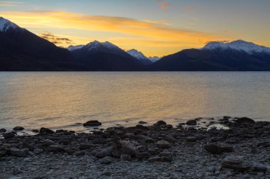 Yeni Zelanda 'nın Güney Adası' ndaki Wakatipu Gölü 'nün üzerinde gün batımı. Ufukta Güney Alpleri 'nin dağları var. 