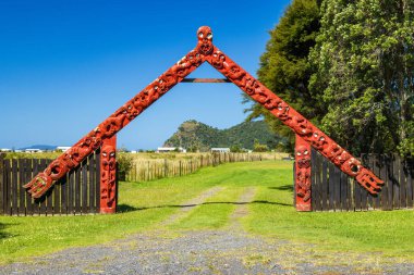 Harataunga Marae 'nin dışında geleneksel Maori oymaları olan ahşap bir kapı. Kennedy Körfezi, Yeni Zelanda' da bir toplantı evi. Fenruary 7, 2026
