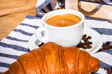 Puf böreği, kahve fincanı ve ahşap sandıkta tereyağlı Fransız kruvasanı. Yemek ve kahvaltı konsepti. Kahve tatlısı ve taze hamur işlerinin detayları.