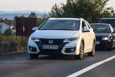 Asfalt yolda hareket halindeki Honda vagonunda, caddedeki arabanın önü. Bükreş, Romanya, 2020