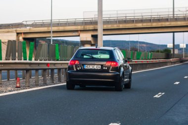 Asfalt yolda ilerleyen siyah bir araba, caddedeki arabanın arka manzarası. Bükreş, Romanya, 2020