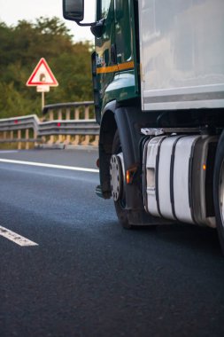 Asfalt yolda, ulaşım ve teslimat konseptinde hareket halindeki yüklü Avrupa kamyonunun yan görüntüsü. Teslimat kamyonunun ayrıntıları. Bükreş, Romanya, 2020