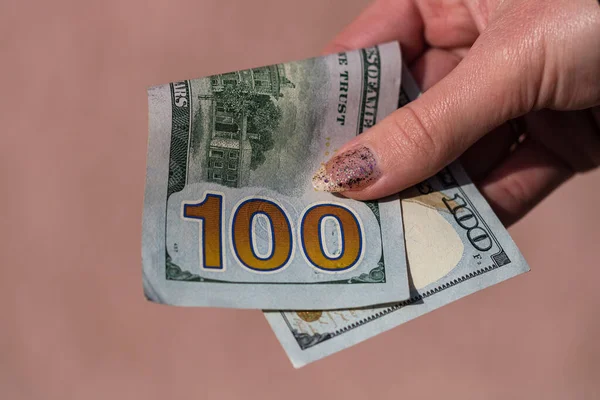 Hands giving money like a bribe or tips. Holding US dollars banknotes on a blurred background, US currency