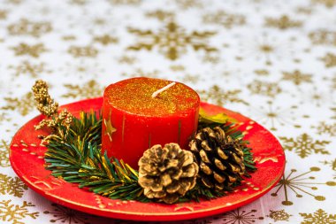 Süslü yılbaşı kırmızı mumuna yakın bir yerde. Noel kompozisyonu, mevsimlik dekorasyonlar ve süsler, renkli Noel arkaplanı Noel havası konsepti.