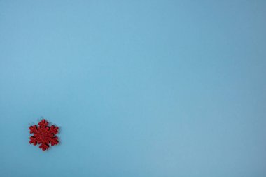 Kırmızı parıltılı kar tanesi süslemeli mavi Noel arkaplanı. Noel kompozisyonunu kopyalamak için üst görünüm.