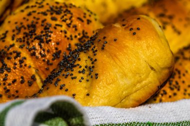 Hamurun içine tuz ve haşhaş tohumu serpiştirilmiş sosislerin detaylarını yakından incele. Sosisli börek, lezzetli ev yapımı hamur işleri..