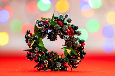 Bulanık ışıkların arka planında izole edilmiş renkli Noel çelenkleri.