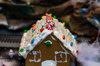 Renkli zencefilli kurabiye evi, bulanık arka planda, Noel süslemesiyle izole edilmiş..