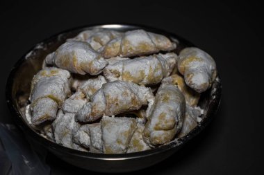 Kısa hamurlu hamur işi kruvasan rulosu, Romanyalı pudra şekerli kornulet izole edilmiş yakın çekim