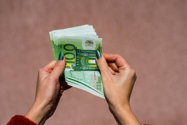 Avro parasını tutmak ve göstermek ya da para vermek. Dünya para kavramı, 100 avro banknot fotokopi alanı ile izole edilmiş para birimi. Zengin iş adamları kavramı, para biriktirmek ya da harcamak.