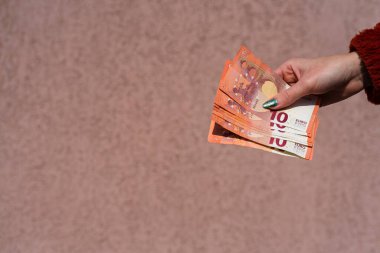 Avro parasını gösteren ve bahşiş, maaş gibi para veren ya da alan el ele tutuşmalar. 10 EURO banknotu EUR izole edilmiş. Zengin iş adamları kavramı, para biriktirmek ya da harcamak.