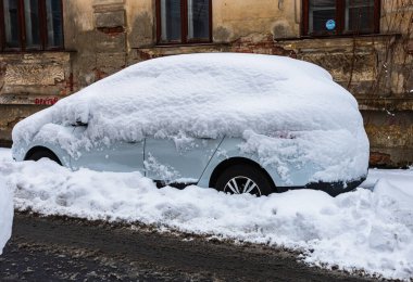 Otoparkta karla kaplı karlı bir araba. Bükreş, Romanya, 2020.