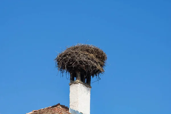 Empty stork nest built on pole isolated.
