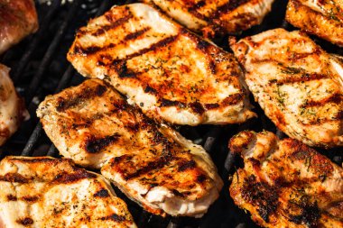 Izgara domuz bifteği. Lezzetli biftekler ızgarada yakın pişiyor.