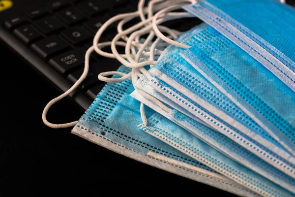 Selective focus on surgical mask isolated on laptop keyboard