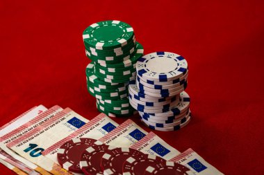 Kırmızı arkaplanda parası olan poker çipleri yığını, EURO para birimi