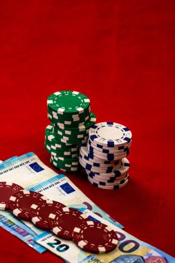 Kırmızı arkaplanda parası olan poker çipleri yığını, EURO para birimi