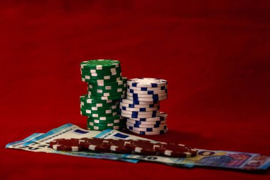 Kırmızı arkaplanda parası olan poker çipleri yığını, EURO para birimi