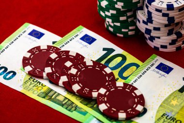 Kırmızı arkaplanda parası olan poker çipleri yığını, EURO para birimi