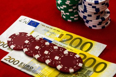 Kırmızı arkaplanda parası olan poker çipleri yığını, EURO para birimi