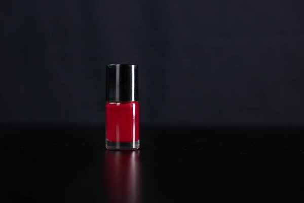 Красочный лак для ногтей бутылку изолированы на черном фоне.