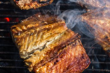 Kömür ızgarasında ızgara uskumru ve duman..