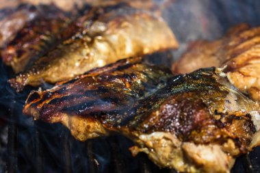 Kömür ızgarasında ızgara uskumru ve duman..