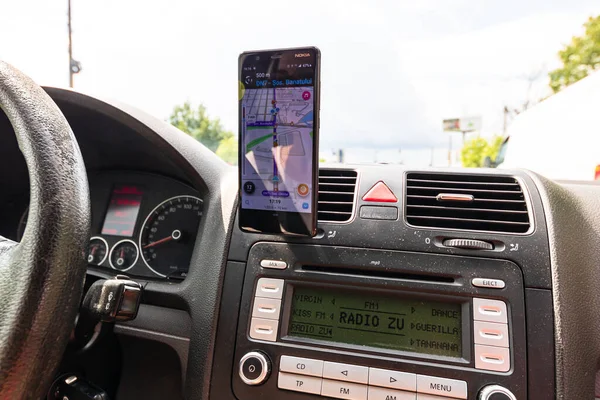 車のダッシュボード上のスマートフォン上の波の地図アプリを使用して ドライバは 雨の夜に都市のトラフィックを介して正しいルートを示すために地図アプリを使用しています ブカレスト ルーマニア 2020年 — ストック写真