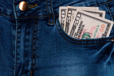 Banknotlar, kot pantolon cebinde para, yakın çekim. Para kotun cebinden çıkar, finans ve para birimi konsepti. Zengin insanlar kavramı, para biriktirmek ya da harcamak.
