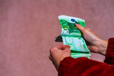 Avro parasını tutmak ve göstermek ya da para vermek. Dünya para kavramı, 100 avro banknot fotokopi alanı ile izole edilmiş para birimi. Zengin iş adamları kavramı, para biriktirmek ya da harcamak.