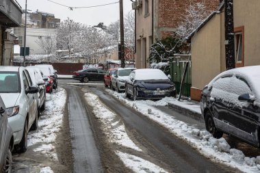 Sabahları arabalarda kar yağar. Kış mevsimi, buzlu arabalar. Kış konsepti: Romanya 'nın Bükreş kentinde donmuş arabalar, 2021