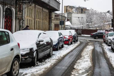 Sabahları arabalarda kar yağar. Kış mevsimi, buzlu arabalar. Kış konsepti: Romanya 'nın Bükreş kentinde donmuş arabalar, 2021