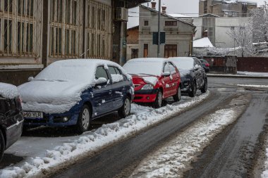 Sabahları arabalarda kar yağar. Kış mevsimi, buzlu arabalar. Kış konsepti: Romanya 'nın Bükreş kentinde donmuş arabalar, 2021