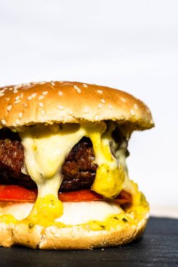 Erimiş peynirli sığır etli çizburger. Beyaz arka planda izole edilmiş ev yapımı çizburger..