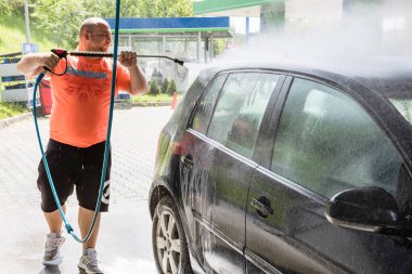 Otomobil yıkama istasyonunda araba yıkama ve temizleme. Bükreş, Romanya 'da yüksek basınçlı su kullanan araba yıkama, 2020