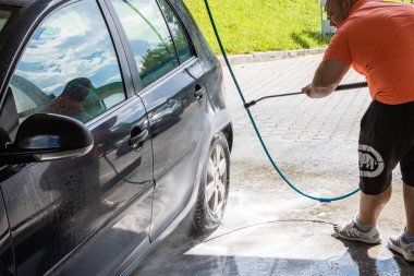 Otomobil yıkama istasyonunda araba yıkama ve temizleme. Bükreş, Romanya 'da yüksek basınçlı su kullanan araba yıkama, 2020